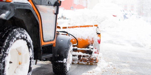 Schneepflug räumt die Straßen in der Stadt, Winterdienst