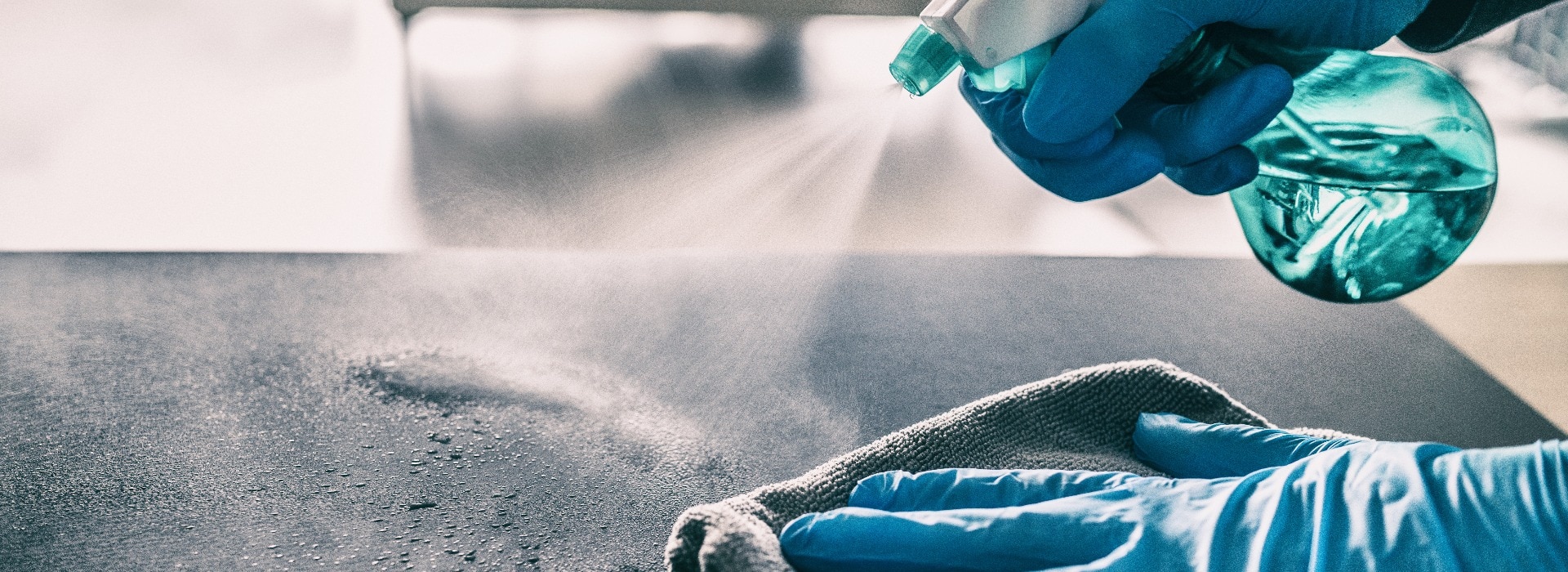 Surface sanitizing against COVID-19 outbreak. Home cleaning spraying antibacterial spray bottle disinfecting against coronavirus wearing nitrile gloves. Sanitize hospital surfaces prevention.